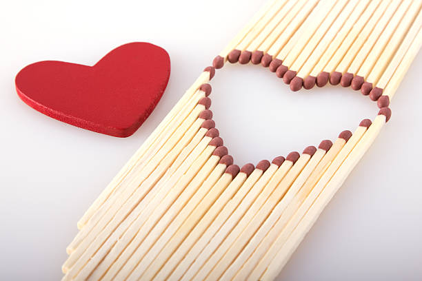 matchstick with a red heart-shaped head on a white background close-up