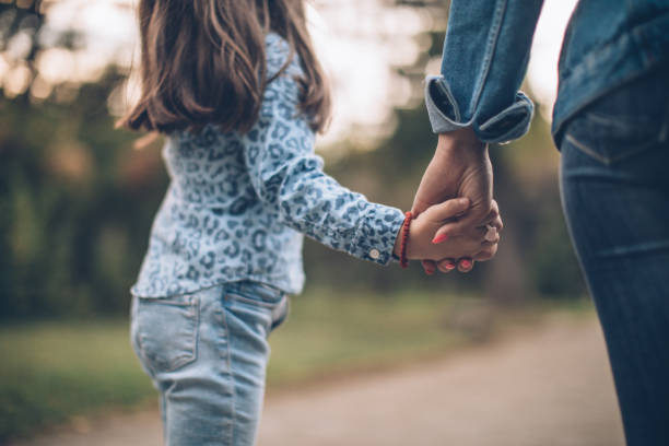 istock Mother and daughter holding hands 1063914534