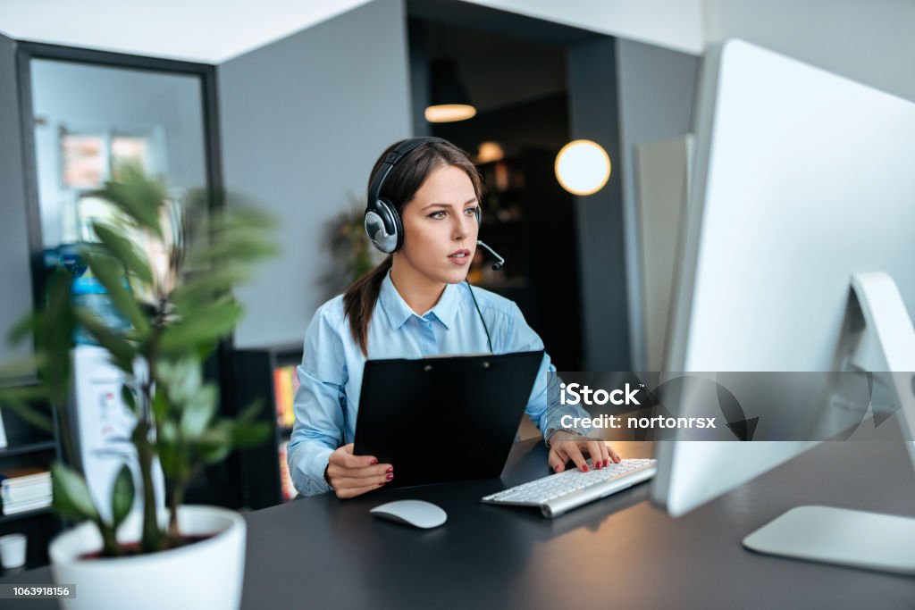 Concentrated young woman working in support center. Call Center Stock Photo