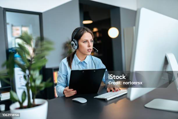 Concentrated Young Woman Working In Support Center Stock Photo - Download Image Now