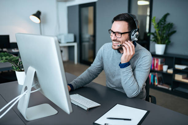 istock Happy agent talking to his clients in support center. 1063924450