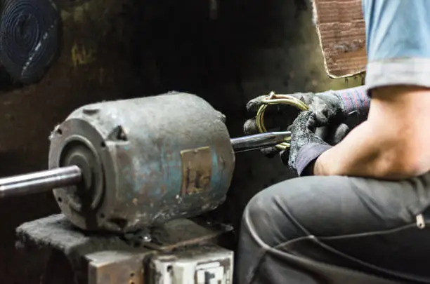 Precious parts polishing machine, Man polishing a jewel in the polisher.