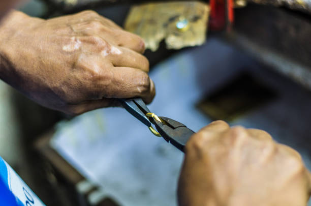 Hands of a jeweler working on a ring with a pliers