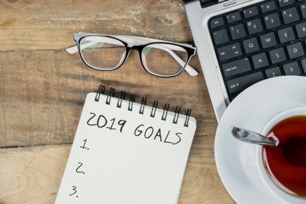 istock Laptop with text of 2019 goals on paper notes 1063945100