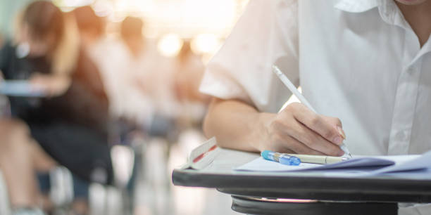 istock School exam student's taking educational test, admission test, thinking hard, writing answer in university classroom, education and world literacy day concept 1063947564