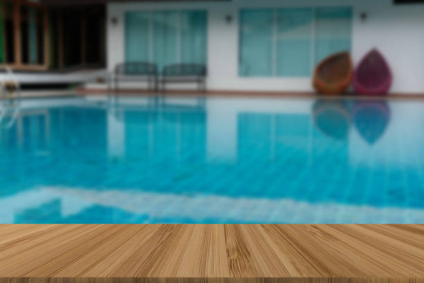 istock swimming pool with wood table for display product 1063947594