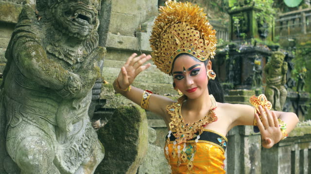 Young Balinese dancer performing Legong dance in a Hindu temple