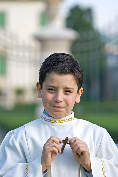 Young child holding Jesus cross on first communion event.
