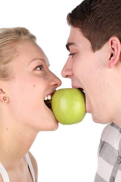 istock girl and  young man bite together green apple 106395425