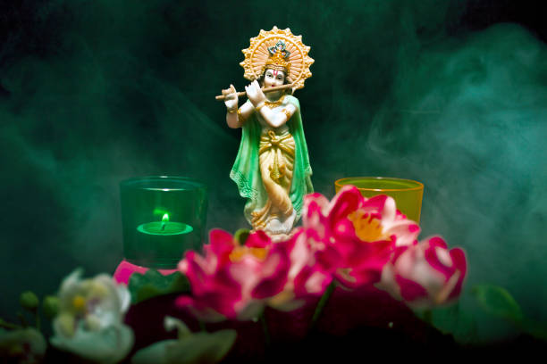 Hindu god Krishna. Hindu god Krishna. Statue with a smoke and lotus flowers on a black background mahabharata stock pictures, royalty-free photos & images