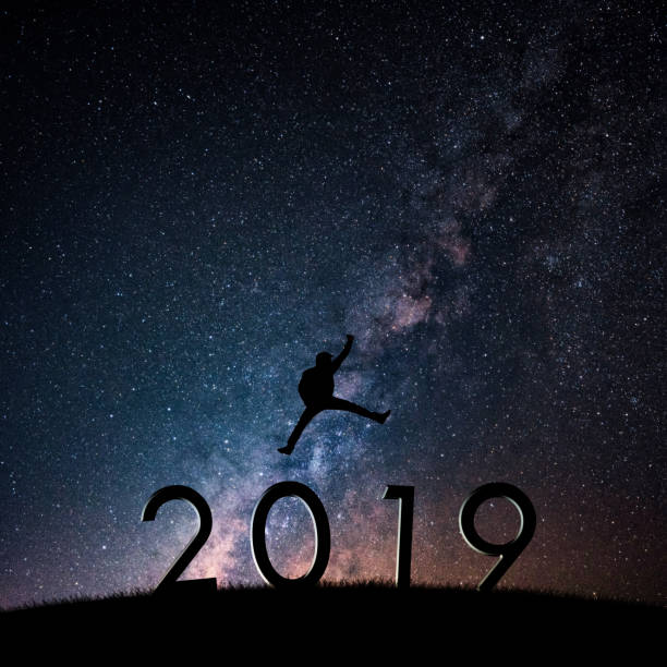 Silhouette of businessman on starry night sky. Freedom or victory concept of Happy New year 2019. stock photo