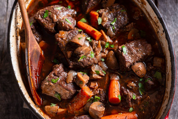 Beef Bourguignon Beef Bourguignon in an Enameled Cast Iron Dutch Oven beef stew stock pictures, royalty-free photos & images