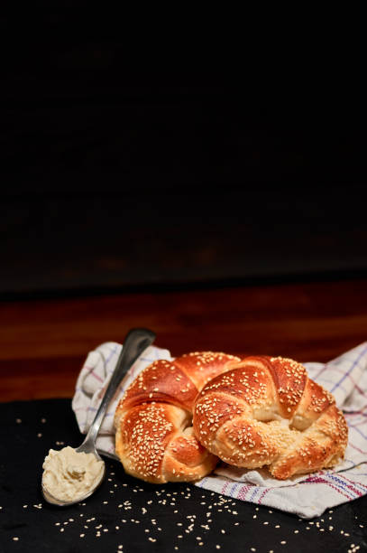 istock Freshly made rolled bun with fresh cheese on black stone cutting board, sprinkled with sesame seeds. Very shallow depth of field 1063964156