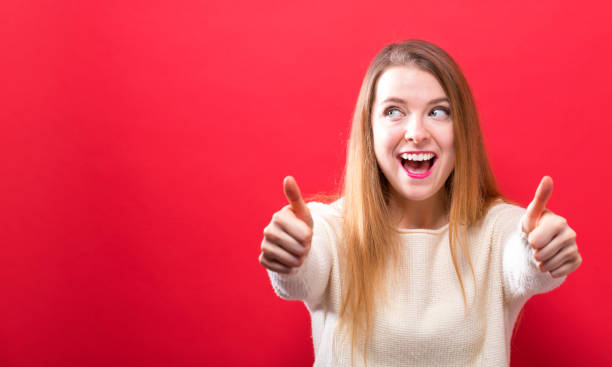 istock Happy young woman giving thumbs up 1063968162