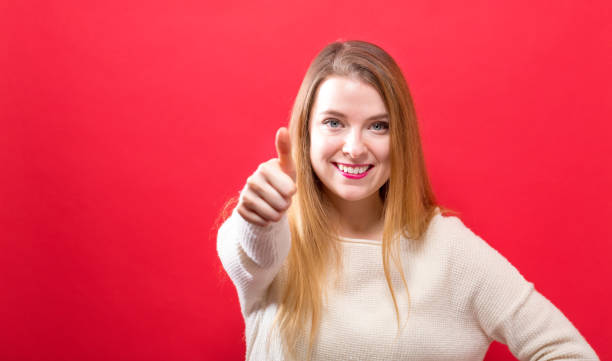 istock Happy young woman giving thumbs up 1063968164