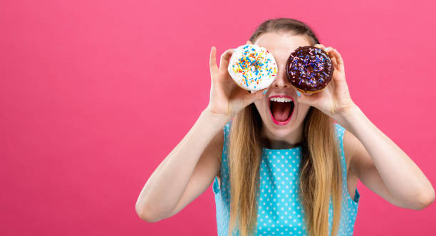 istock Young woman with donuts 1063968294