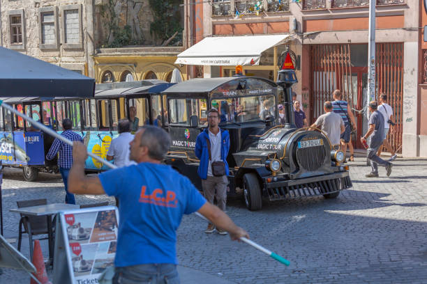 view of a tourist train on street and people in the center of the porto city - voyagers imagens e fotografias de stock