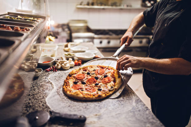 istock Chef takes out a hot pizza from the oven 1063976344