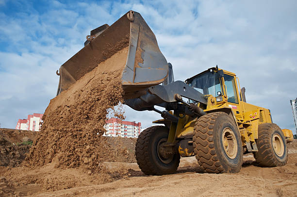 wheel loader at eathmoving works Wheel loader machine unloading sand at eathmoving works in construction site construction equipment stock pictures, royalty-free photos & images