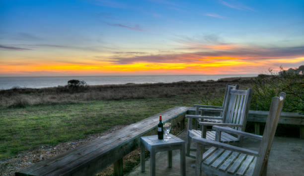 die sea ranch, kalifornien: sonnenuntergang auf dem deck mit wein und gläser durch schaukelstühle - mendocino county northern california california coastline stock-fotos und bilder