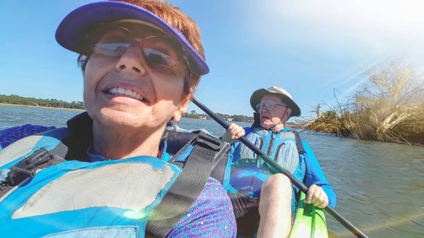 Selfie of two seniors kayaking Selfie of senior couple kayaking in lagoon in South Carolina; senior woman in the front, senior man in the back kiawah island stock pictures, royalty-free photos & images