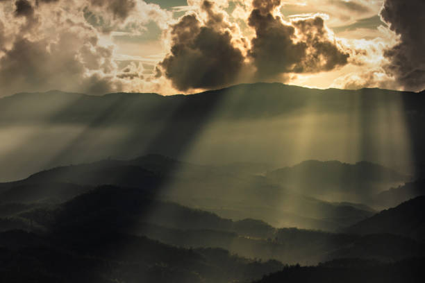 istock sunbeam shining through cloud. and lid space between mountain. multiple layers of mountain ranges. 1064012176