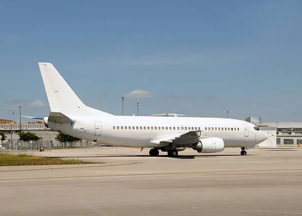 Unmarked white passenger jet airplane side view