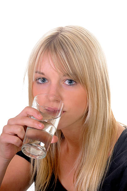 mujer joven con agua de vidrio - wasserglas fotografías e imágenes de stock