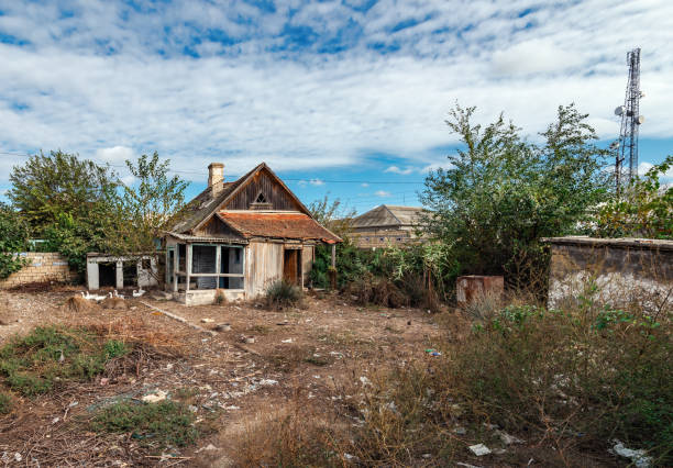 Old abandoned wooden rural house and yard