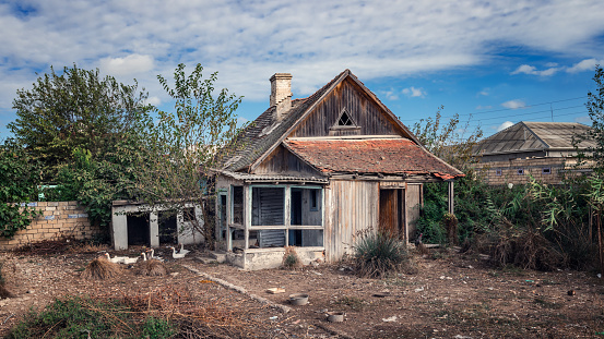 Old abandoned wooden rural house and yard