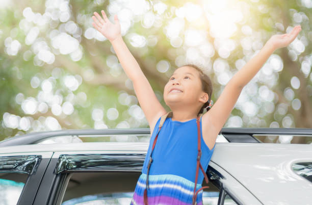 istock Happy kid with raised arms from window car 1064019394