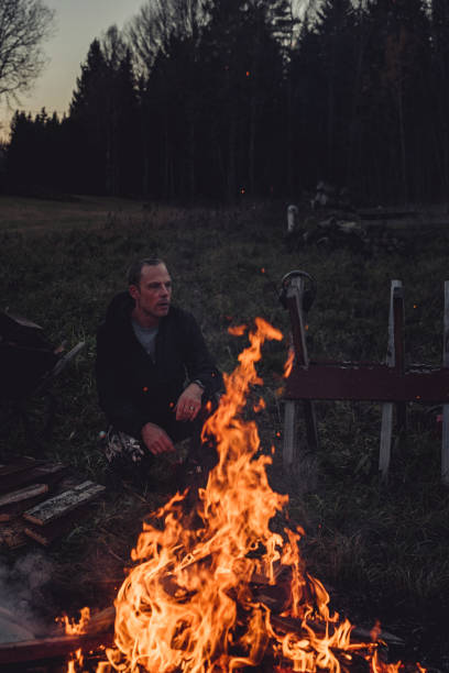 istock Man burning wood waste outdoors in evening disposal of burnable waste 1064023366