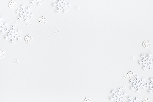 Composición de Navidad. Marco de Navidad hecho de copos de nieve sobre fondo gris pastel. Concepto de invierno. Endecha plana, alta vista, espacio de copia photo