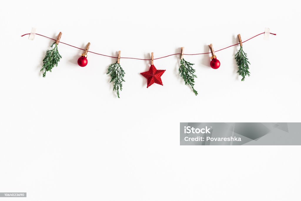 Composizione natalizia. Ghirlanda fatta di palline rosse e rami di abete su sfondo bianco. Concetto di Natale, inverno, capodanno. Lay piatto, vista dall'alto, spazio di copia - Foto stock royalty-free di Natale