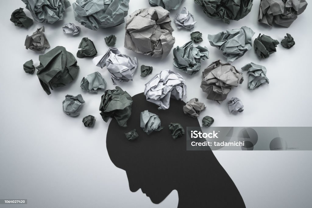 Silhouette of troubled person head. Concept image of anxiety and negative emotion. Waste paper and head silhouette. Anxiety Stock Photo