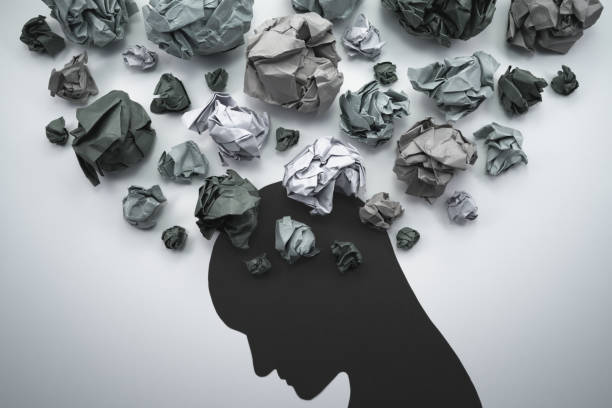 Silhouette of troubled person head. Concept image of anxiety and negative emotion. Waste paper and head silhouette. mental wellbeing stock pictures, royalty-free photos & images