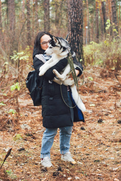 istock woman with huski dog in a park 1064033224
