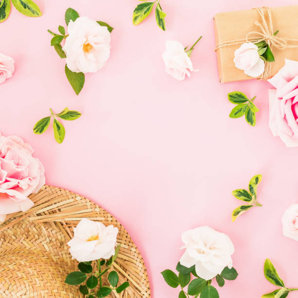 istock Valentines day. Floral frame with roses, straw hat and gift on pastel pink background. Flat lay, top view. 1064039980