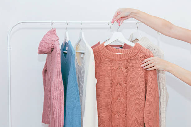 istock Woman choosing pastel warm cozy sweaters on hangers. 1064043498