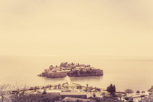 Retro sepia vintage image of the historical Sveti Stefan old town, landmark on the coast of Montenegro