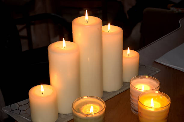 istock Burning candles on a wooden table against a dark room background 1064044620