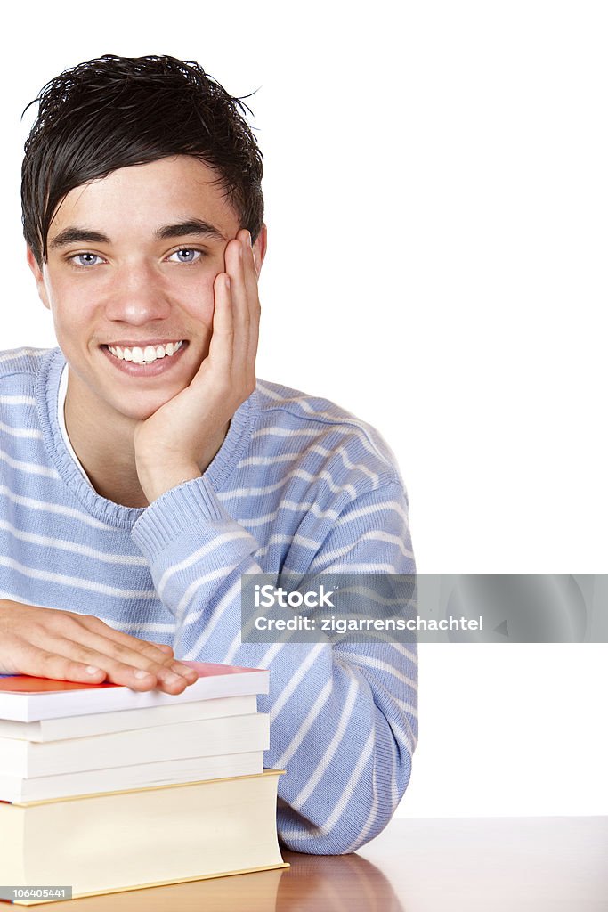 Молодой счастливый улыбающийся мужчина студент, сидя на стол с книги - Стоковые фото Белый фон роялти-фри