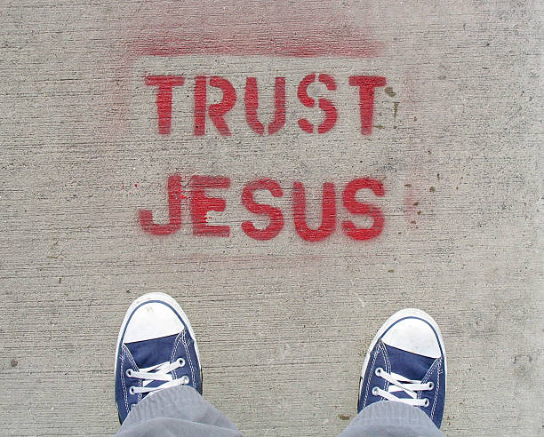 Spray painted tag lined trust Jesus with overlooking guy