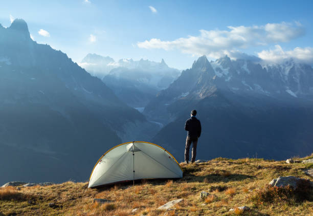 Campsite view Hiker enjoying the view and a cup of coffee at his campsite in the mountains. Chamonix, France. aiguille de midi photos stock pictures, royalty-free photos & images