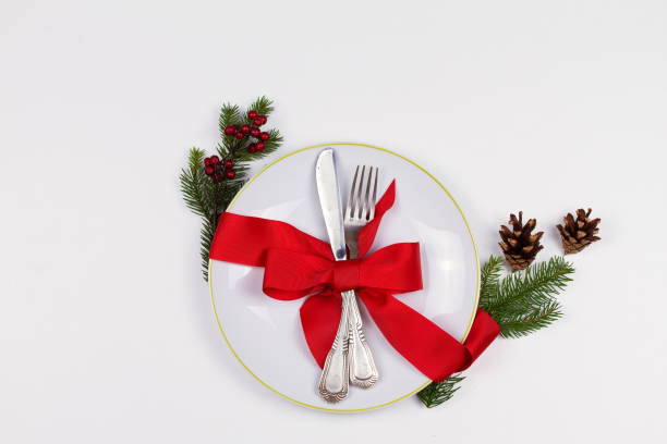 istock Christmas composition with plate, cutlery, pine branches, ribbon and red berries on white table 1064066464