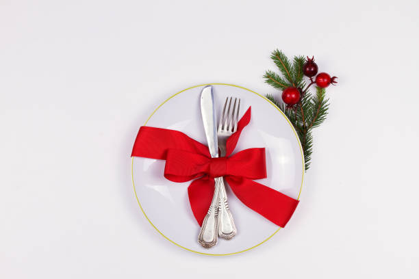 istock Christmas composition with plate, cutlery, pine branches, ribbon and red berries on white table 1064066608
