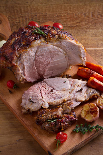 istock Baked ham with vegetables, rosemary and thyme on chopping board 1064070828