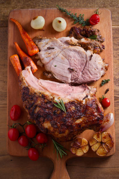 istock Baked ham with vegetables, rosemary and thyme on chopping board 1064071180