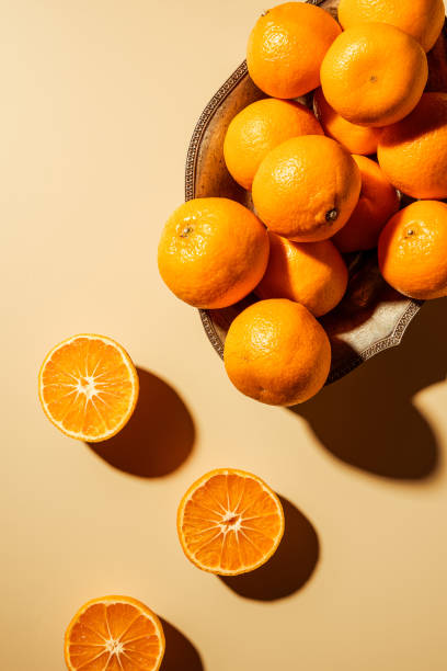 istock Flat lay with tangerines in metal bowl on beige backdrop 1064074648