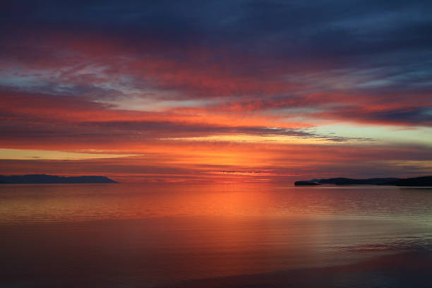 istock Flaming sunset in sea, bay at sunrise. 1064074810